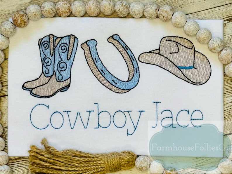 Puede incluir: Dise&ntilde;o bordado en una tela blanca con un par de botas de vaquero, una herradura, un sombrero de vaquero y el texto "Cowboy Jace".