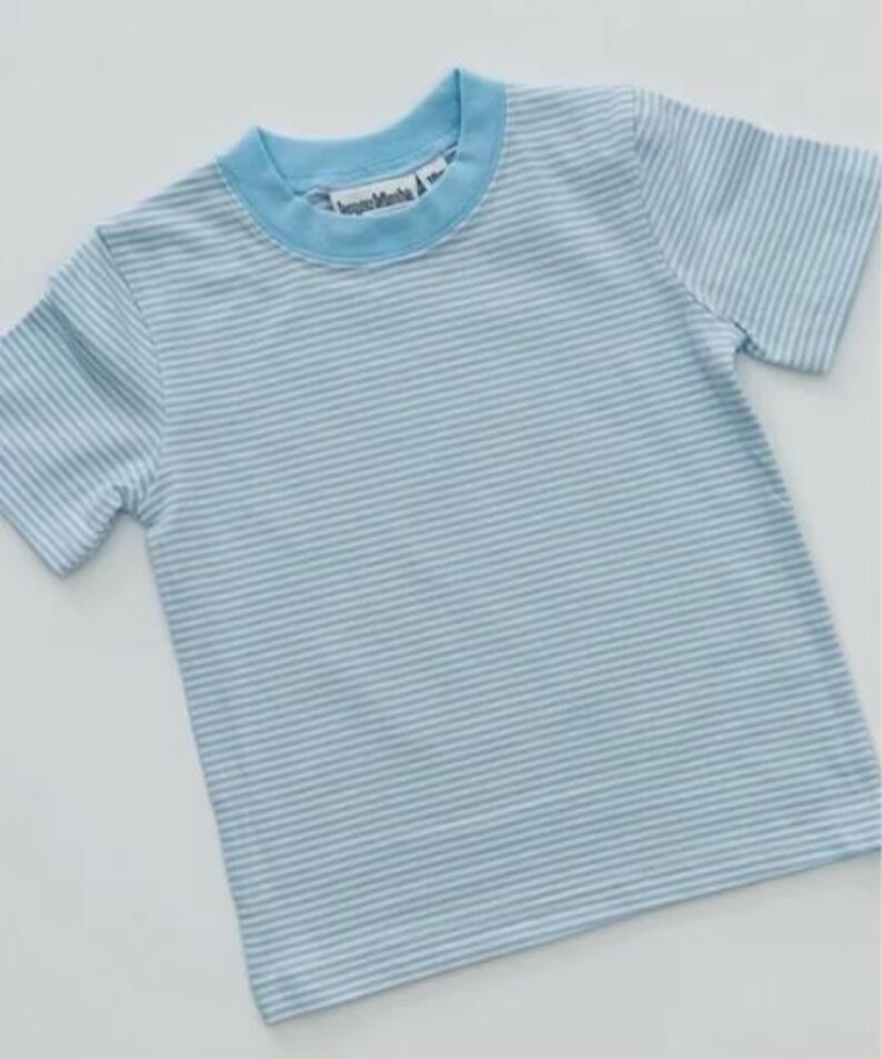K&ouml;nnte beinhalten: Hellblau-wei&szlig; gestreiftes T-Shirt mit hellblauem Kragen und &Auml;rmeln. Das Shirt hat ein Etikett mit der Aufschrift "happy Mamba". Das Shirt ist aus einem weichen Material gefertigt.