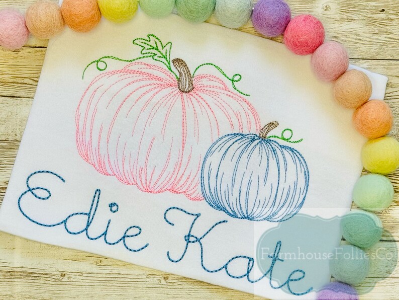Puede incluir: Dise&ntilde;o bordado de dos calabazas, una rosa y una azul, con los nombres "Edie Kate" cosidos debajo.