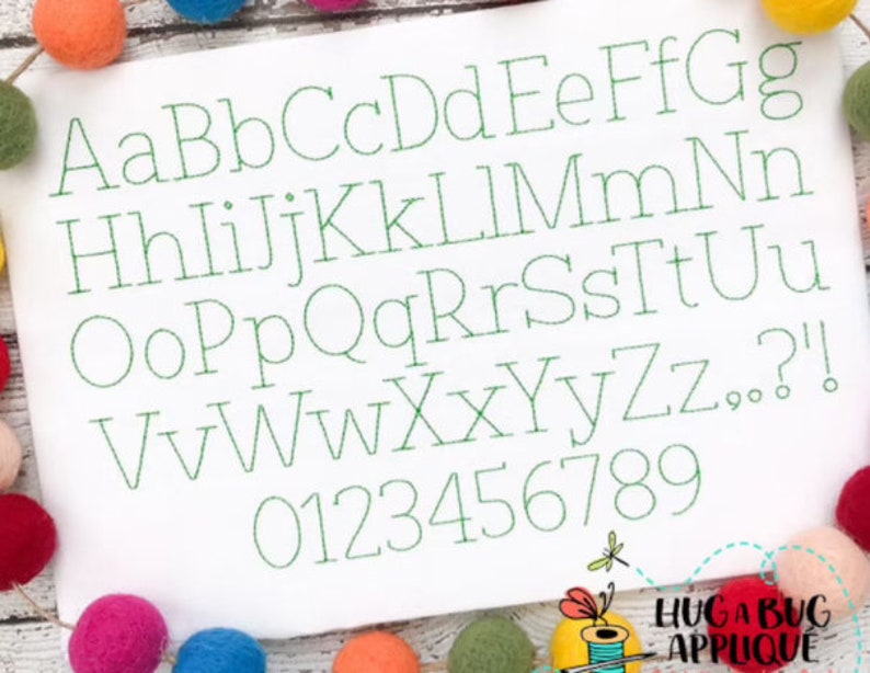 May include: A white background with a green embroidered alphabet and numbers. The letters are in a simple, classic font. The letters are A-Z and the numbers are 0-9.