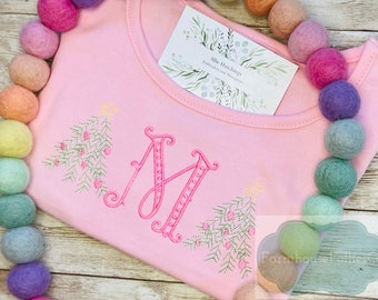 May include: Pink baby onesie with a pink embroidered letter N and two Christmas trees with red berries. The text "Allie Hutchins Embroidery and Monograms" is on a white card in the background.