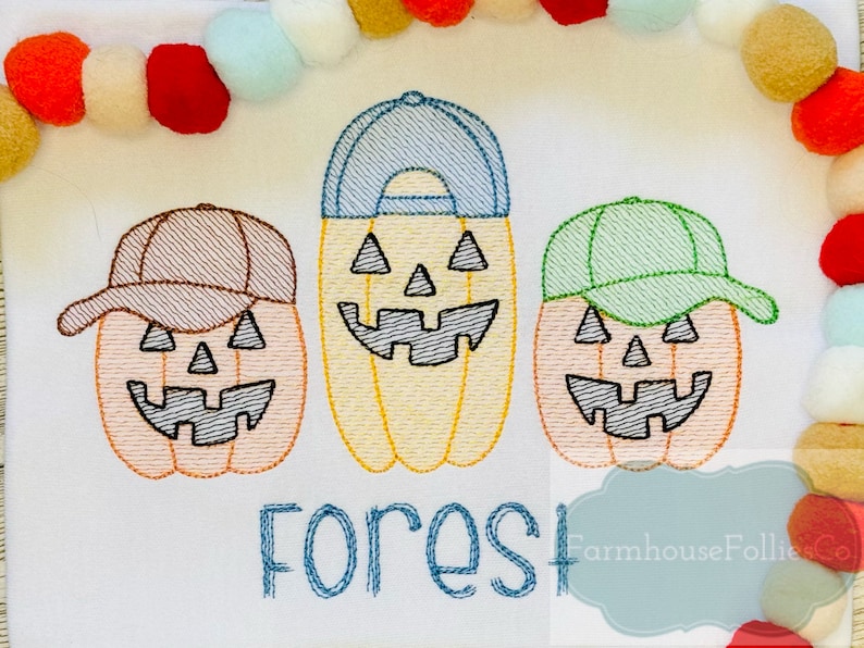 May include: Three embroidered pumpkin faces wearing baseball caps in brown, blue, and green. The pumpkins are orange and have black eyes, noses, and mouths. The text "Forest" is embroidered below the pumpkins.