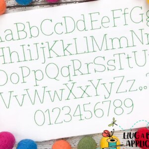 May include: A white background with a green embroidered alphabet and numbers. The letters are in a simple, classic font. The letters are uppercase and the numbers are in a standard font.