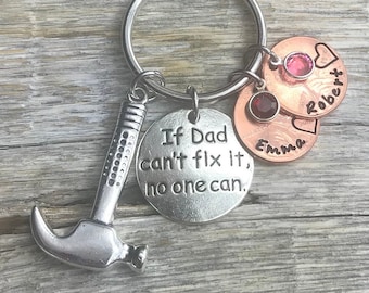 Peut inclure: Porte-clés en argent avec un charme marteau et un charme en argent avec le texte "Si papa ne peut pas le réparer, personne ne le peut.". Il y a aussi deux charmes en cuivre avec les noms "Emma" et "Robert" gravés dessus.