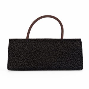 May include: A rectangular black handbag with a textured surface and a curved brown handle. The bag has a simple, elegant design, suitable for various occasions. The handle is made of a smooth, dark brown material.