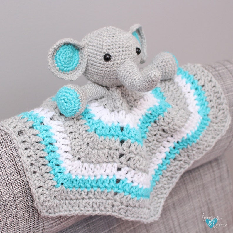 May include: A gray crocheted elephant with turquoise ears and a white and turquoise striped blanket. The blanket has a crocheted border.