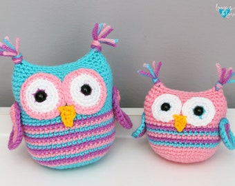May include: Two crocheted owls, one pink and one blue, with pink and purple stripes. Both owls have white eyes with black pupils and yellow beaks.