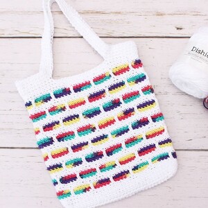 May include: White crochet tote bag with colorful stripes. The bag has a single handle and is made with a simple stitch pattern.