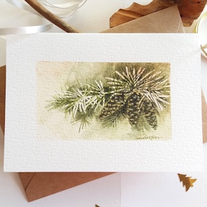 Carte peinte à la main. Pommes de pin de Noël. Mini peinture de paysage à l'aquarelle.
