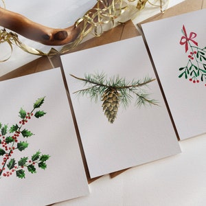 Tarjeta navideña. Juego de 3 cartas surtidas. Hojas de acebo. Cono de pino. Muérdago de cinta roja. Tarjetas de felicitación navideñas originalmente pintadas a mano.