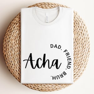 May include: White t-shirt with black text that reads "Acha Dad. Friend.  Bruh."