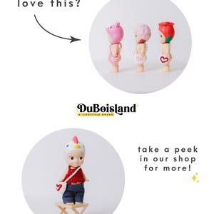 以下が含まれることがあります： 画像には、豚、雲、バラの形をしたヘッドウェアをかぶった3つの小さなフィギュアが写っています。4つ目のフィギュアは鶏の帽子をかぶっており、小さな木製のスツールの上に立っています。「love this?」と「take a peek in our shop for more!」というテキストも表示されています。