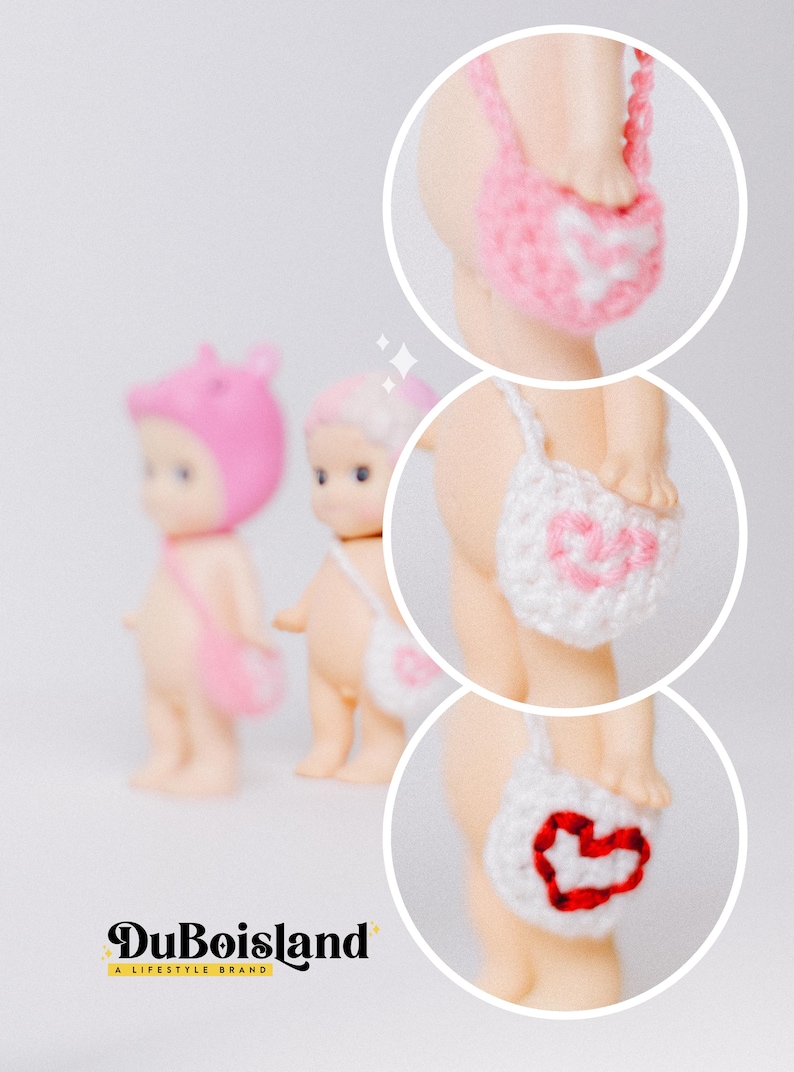以下が含まれることがあります： ピンク、白、赤のハート型の編み物アクセサリーを身につけた、3体の小さなヌードカラーの人形。DuBoislandのロゴが画像の下部に表示されています。