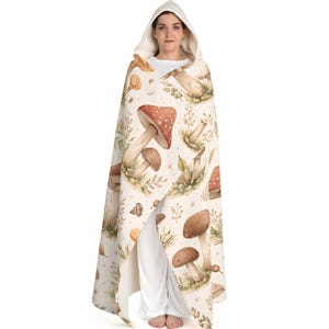 May include: A set of three ceramic mugs with a speckled, cream-coloured glaze. Each mug features a different hand-painted floral design in shades of blue, green, and yellow. The mugs have a simple, modern shape.