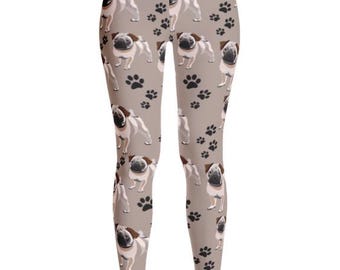May include: Taupe leggings featuring a repeating pattern of pugs and paw prints. The pugs are depicted in a realistic style with brown and black markings. The paw prints are black. The leggings are form-fitting and made of a stretchy material.