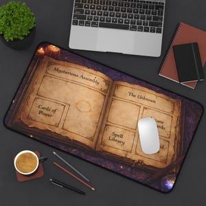 May include: A large rectangular mousepad featuring an open book design with the words "Mysterious Assembly" and "The Unknown." The design includes sections labeled "Cards of Power" and "Spell Library." A white mouse sits on the pad.