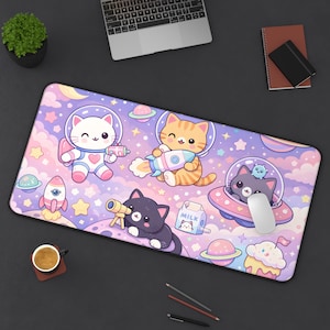 May include: A rectangular mousepad featuring a whimsical space-themed design with cartoon cats in astronaut suits, planets, rockets, and stars. The color palette includes pastel pinks, purples, and blues, creating a playful and imaginative scene.