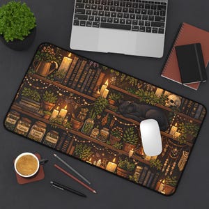 May include: A decorative desk mat featuring a whimsical illustration of a bookshelf with candles, plants, and a sleeping black cat. Jars of herbs and a skull are also visible. A computer mouse and keyboard are on the desk.