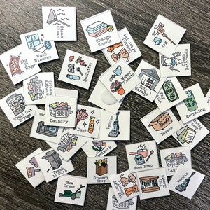 May include: A set of colourful square chore cards with illustrations and text. The cards include chores such as laundry, vacuuming, cleaning the bathroom, and paying bills.