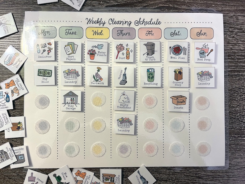 May include: A white weekly cleaning schedule chart with colourful squares and icons representing different chores. The chart is divided into days of the week, with each day having a different colour. The icons include a broom, a vacuum cleaner, a laundry basket, a bin, and a watering can. The chart is designed to help people stay organised and on top of their cleaning tasks.