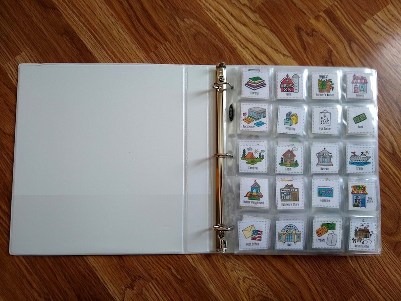 May include: A white binder with clear plastic pockets containing colorful illustrations of various places and activities. The illustrations include a library, farm, farmer's market, housing, rec center, shopping, eye doctor, bank, camping, cabin, museum, cruise, indoor playground, hardware store, aquarium, toy store, post office, mall, friends, and a nature center.