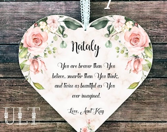 Puede incluir: Un letrero de madera blanco en forma de corazón con un diseño floral y el texto "Nataly You are braver than You believe, smarter than You think, and twice as beautiful as You ever imagined. Love, Aunt Kay"