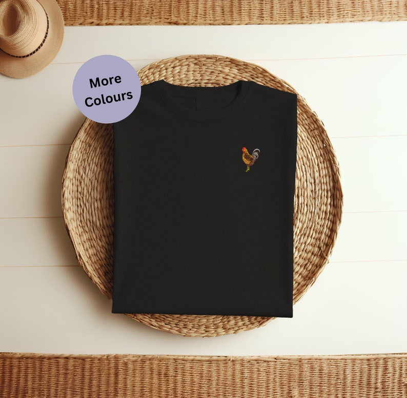 May include: Black t-shirt with a small embroidered rooster design on the left chest. The rooster is brown, yellow, and red.