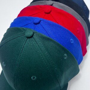 Peut inclure: Un ensemble de six casquettes de baseball vierges de diff&eacute;rentes couleurs, notamment vert, bleu, rouge, gris et noir.
