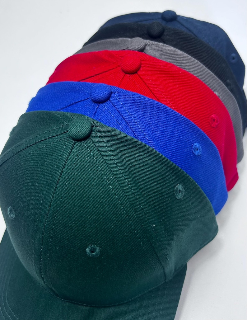 Peut inclure: Un ensemble de six casquettes de baseball vierges de diff&eacute;rentes couleurs, notamment vert, bleu, rouge, gris et noir.