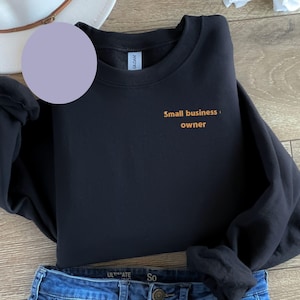 May include: Black sweatshirt with the text "Small business owner" in orange lettering.