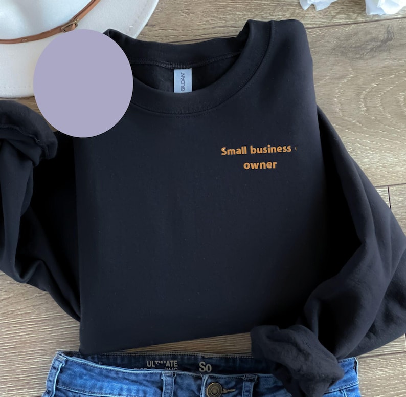 May include: Black sweatshirt with the text "Small business owner" in orange lettering.