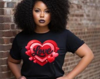 Puede incluir: Camiseta negra con un diseño de corazón y la palabra "Love". El corazón tiene capas de elementos rojos y rosas, rodeado de corazones más pequeños. La persona que lleva la camiseta tiene el pelo rizado oscuro y está apoyada en una pared de ladrillos.