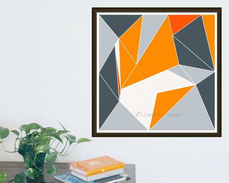 May include: Abstract geometric print with a design of triangles in orange, grey, and white. The artwork is set against a white background and framed in a dark brown frame. The print is signed "LineColorDesign".