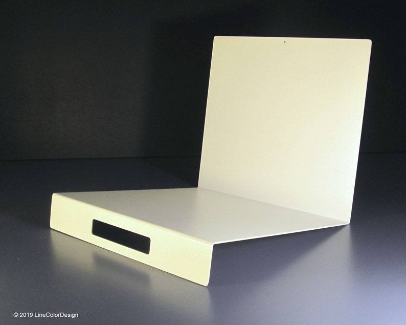 May include: A white, L-shaped metal shelf with a rectangular cutout. The shelf has a flat base and a vertical back panel. The design is minimalist and modern, with a clean, smooth surface. The background is dark.