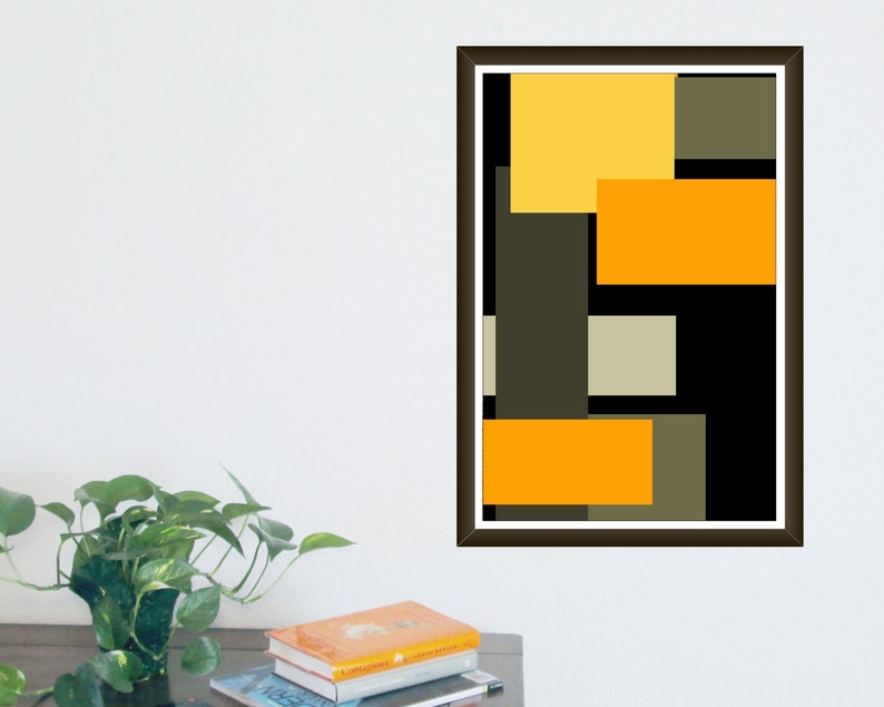 May include: Abstract art print featuring a geometric design with overlapping rectangles in yellow, orange, gray, and black. The artwork is framed in a dark brown frame and is displayed on a white wall.