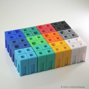 May include: A collection of colorful, modular building blocks in shades of blue, green, red, orange, yellow, gray, black, and white. Each block has a square top with four holes and a rectangular base with vertical supports. The blocks are arranged in a grid pattern.