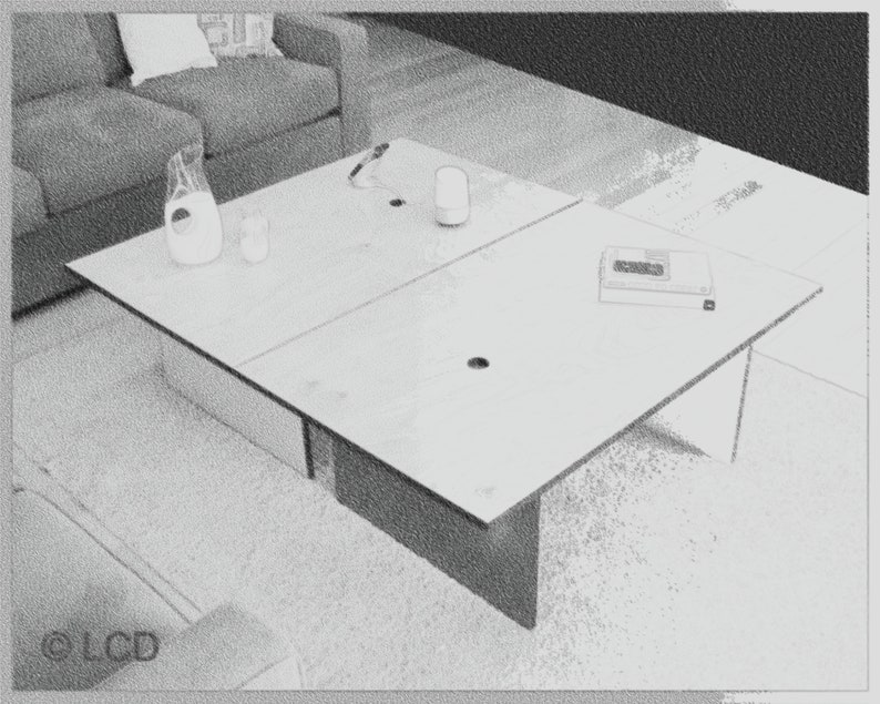 May include: A light-colored, modern coffee table with a rectangular top, divided into four sections. A pitcher, two glasses, and a small electronic device are on the table. The table is in front of a gray sofa.