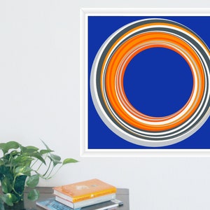 Może przedstawiać: Abstrakcyjny wydruk artystyczny z okrągłym wzorem. Grafika przedstawia koncentryczne pierścienie w odcieniach pomarańczu, szarości, bieli i czerni na głębokim niebieskim tle. Wydruk jest oprawiony w białą kwadratową ramę.