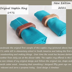 May include: Two wooden napkin rings, one from 1971 and a new edition from 2021, each encircling a teal napkin. The rings are made of dark wood. The text on the image reads "My Original Napkin Ring 1971" and "New Edition 2021".