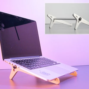 May include: A laptop computer resting on a wooden stand. The stand is angled to elevate the laptop. The stand is made of light-colored wood and has a simple, modern design. An additional image shows a silver metal laptop stand.