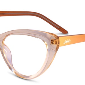 Op de afbeelding: Een paar amberkleurige cat-eye brillen met een heldere lens. De bril heeft een dun, bruin montuur en de merknaam "Misto" staat gedrukt op de rechter poot.