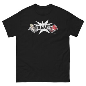May include: Black t-shirt featuring a cartoon angel and devil shooting at each other, with the word "BLAH" in a starburst. The angel is white, and the devil is red. The shirt is a classic fit.
