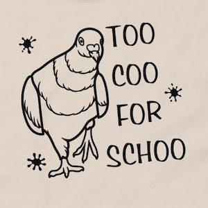 May include: A beige t-shirt with a black illustration of a pigeon and the text "TOO COO FOR SCHOO".