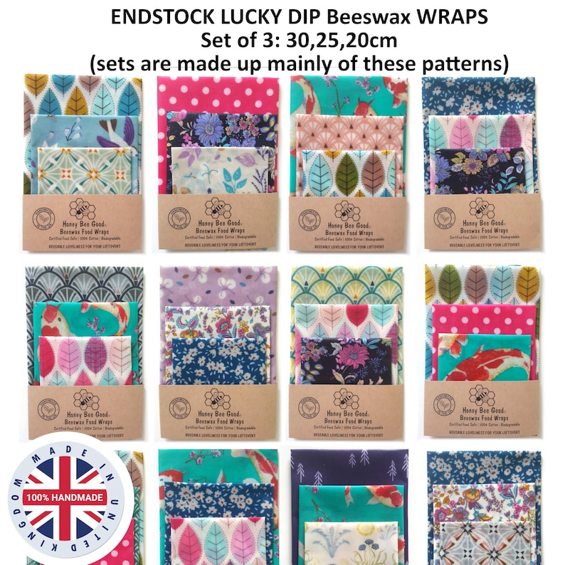 May include: A set of three beeswax food wraps in various patterns and colors, including floral, leaf, and koi fish designs. Each set includes sizes of 30, 25, and 20 cm. The wraps are secured with a brown paper band labeled Honey Bee Good.