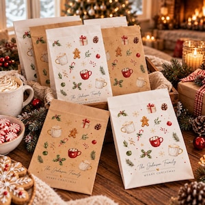 Könnte beinhalten: Eine Sammlung von weißen und braunen Geschenktüten aus Papier mit einem festlichen Muster aus Lebkuchenmännern, Tassen mit heißer Schokolade, Tannenzapfen und Stechpalmen. Jede Tüte ist mit dem Text The Johnson Family und Merry Christmas bedruckt.