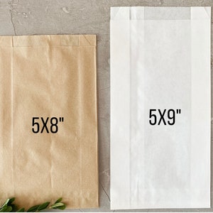 K&ouml;nnte beinhalten: Zwei Papiert&uuml;ten, eine braune und eine wei&szlig;e, mit den Ma&szlig;en 5x8 Zoll und 5x9 Zoll bedruckt.