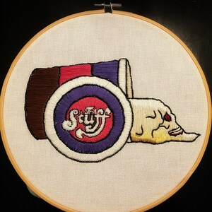 May include: Embroidered design of a red, white, and brown can with the word "Stuff" in a purple circle. The can is lying on its side and a white skull with red eyes is coming out of the can.