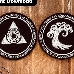 May include: Two black embroidered patches with white designs. One features a triangle with a central circular design, the other a stylized tree. Both are circular with a decorative border. The patches are approximately 8.4 cm in diameter.