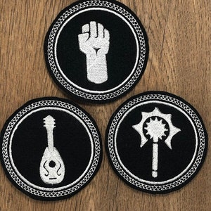May include: Three black and white embroidered patches with a white border. The patches feature a fist, a lute, and a spiked mace.
