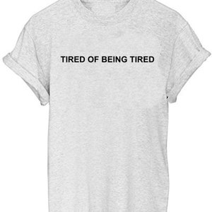 May include: A gray t-shirt with the text "TIRED OF BEING TIRED" printed in black.